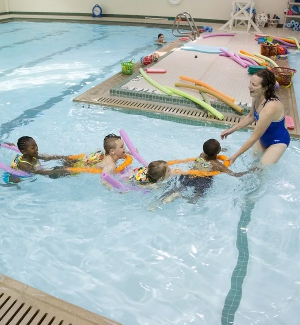 Swim instructor teaching swim lesson in an indoor pool