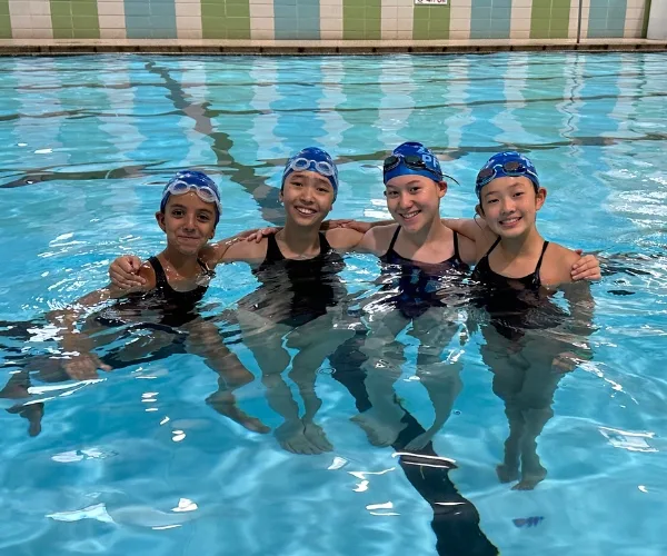 Youth swim team inside indoor pool