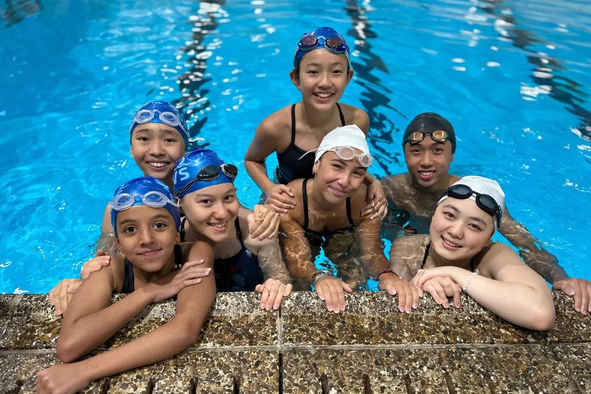 Youth swim team inside indoor pool