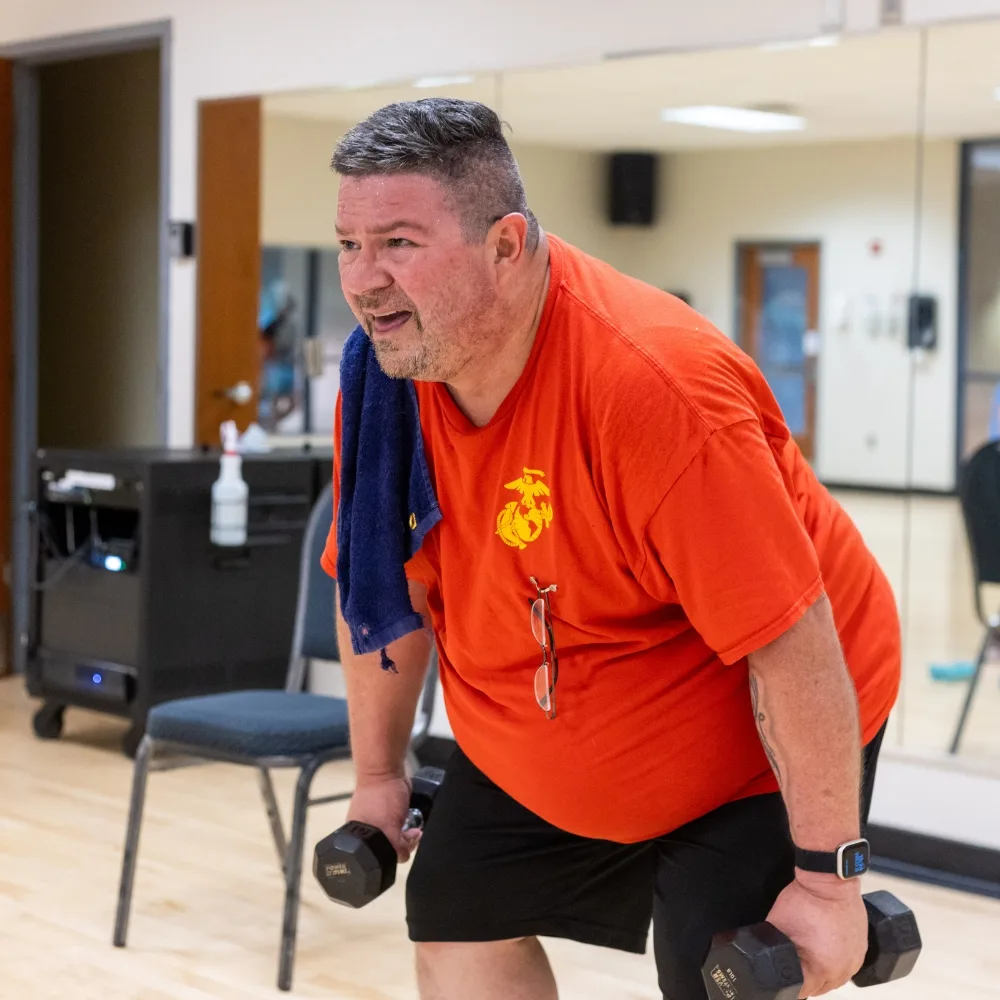 Veterans Wellness member training with weights inside studio