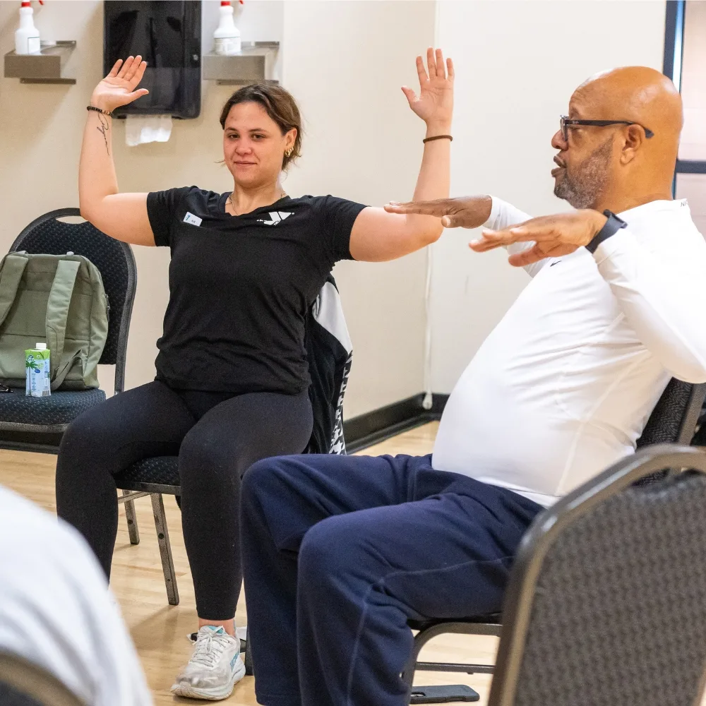 Veterans Wellness trainer teaching chair yoga inside a studio