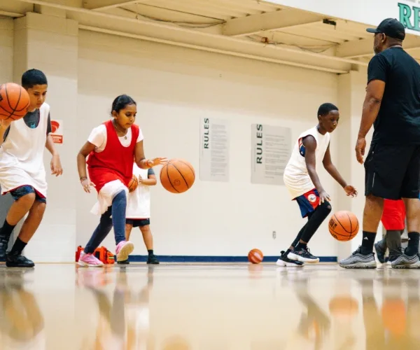 Basketball coach teaching youth basketball team