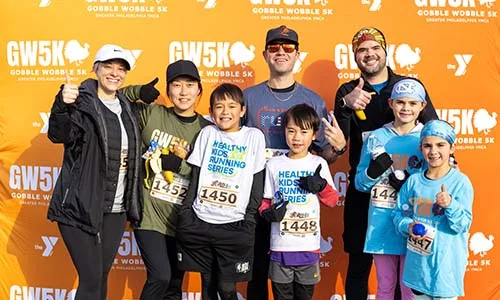 Group of 5K running finishers giving thumbs up