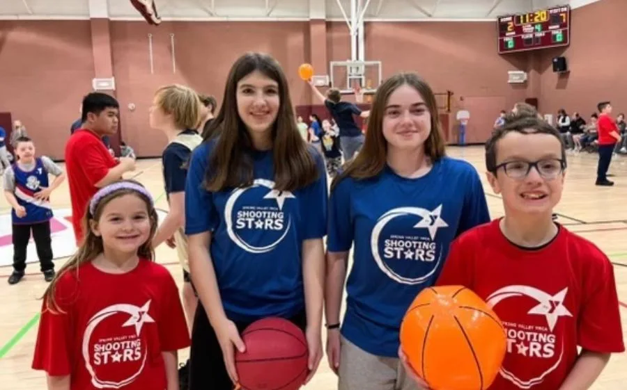 Children holding basketballs at Shooting Stars event inside gymnasium